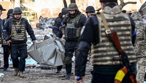 Policías ucranianos sacan un cuerpo de un edificio residencial de cinco pisos que se derrumbó parcialmente después de un bombardeo en Kiev. (Foto: Serguéi SUPINSKY / AFP)