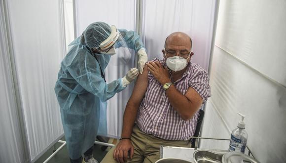 Un trabajador de la salud inocula a un voluntario con una vacuna COVID-19 producida por el chino Sinopharm durante su ensayo en el Centro de Estudios Clínicos de la Universidad Cayetano Heredia en Lima el 09 de diciembre de 2020 (Foto: Ernesto Benavides / AFP)