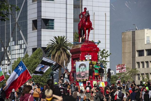 La gente protesta frente al monumento al General Baquedano -pintado de rojo- contra el gobierno del presidente de Chile, Sebastián Piñera, en la Plaza Itali, el 16 de octubre de 2020. (Foto de Martín BERNETTI / AFP).