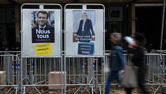 Los peatones pasan frente a los carteles de campaña del presidente francés y candidato Emmanuel Macron y la candidata Marine Le Pen. (Foto: Pascal GUYOT / AFP)