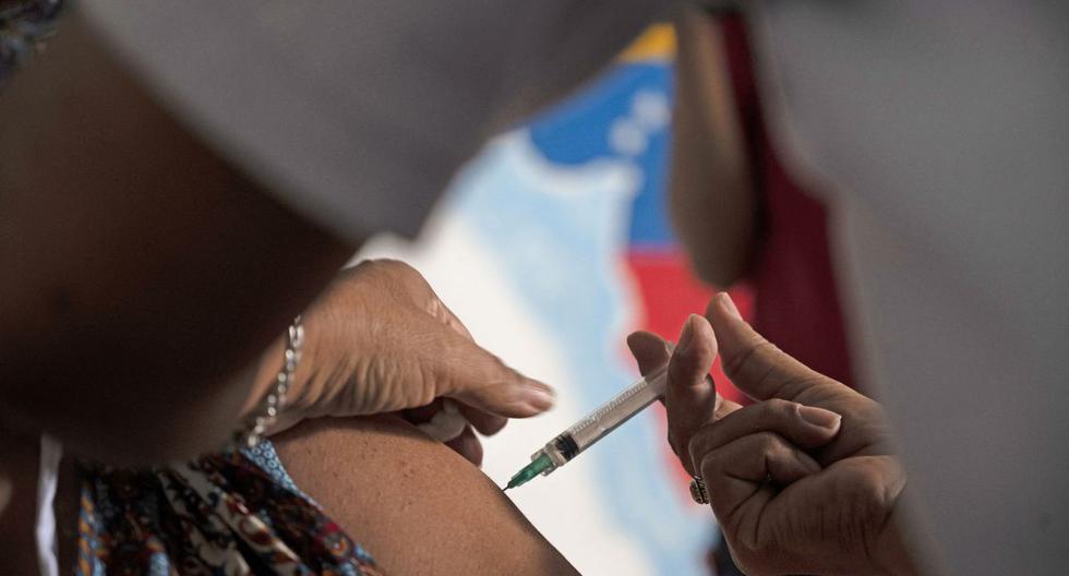 Un docente recibe una dosis de la vacuna COVID-19 desarrollada por Sinopharm de China en un centro de vacunación en la escuela secundaria Miguel Antonio Caro en Catia, Venezuela, el 8 de marzo de 2021. (Yuri CORTEZ / AFP).