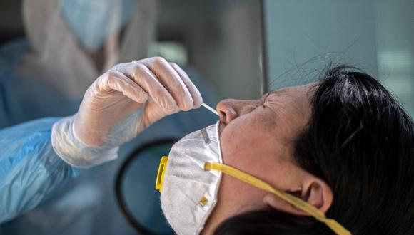 Una mujer se somete a una prueba de PCR para el nuevo coronavirus en el centro médico móvil del municipio de El Bosque, en Santiago, el 25 de agosto de 2020.  (Martin BERNETTI / AFP).