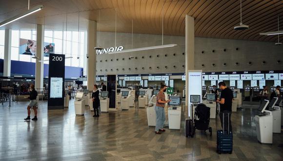 Los viajeros son fotografiados en las estaciones de auto check-in dentro de la Terminal 2 del aeropuerto de Helsinki el 19 de agosto de 2022, en Vantaa, Finlandia. (Foto de Alessandro RAMPAZZO / AFP)