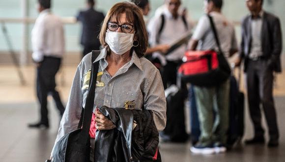Una mujer usando una mascarilla en el aeropuerto en medio de la lucha contra el coronavirus. Foto: AFP