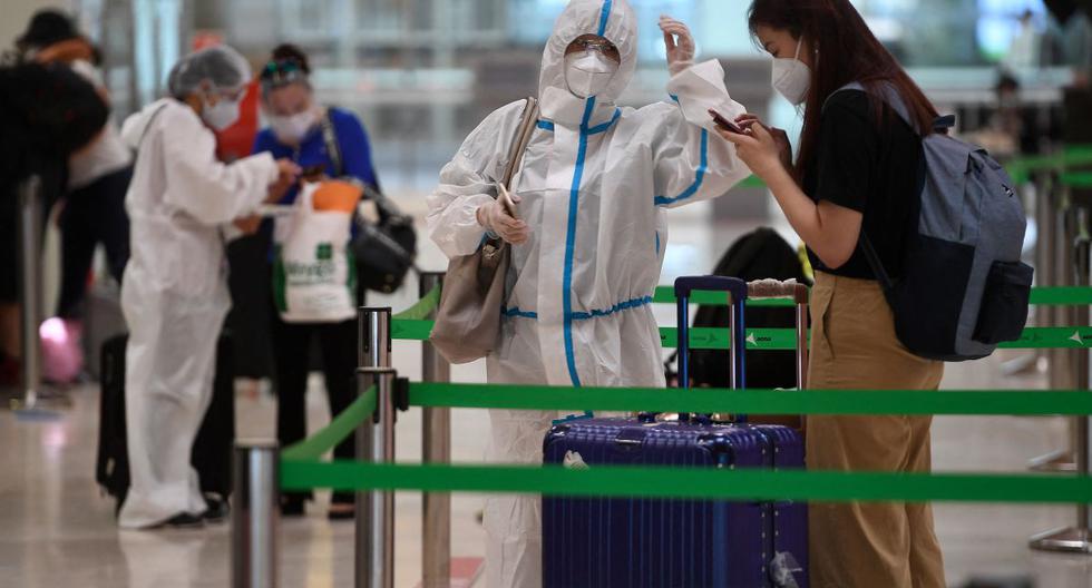 Un pasajero con un traje de protección espera para registrarse para un vuelo en el aeropuerto de Barajas, en Madrid (España), el 20 de junio de 2020. (PIERRE-PHILIPPE MARCOU / AFP).
