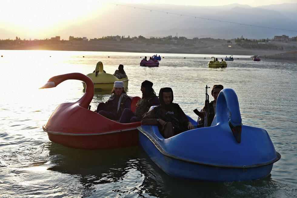 Sin abandonar nunca sus armas, parten de a dos hacia el centro del lago en sus pequeños botes rosados, azules, verdes o amarillos, riendo cuando chocan entre ellos. (Foto: WAKIL KOHSAR / AFP)