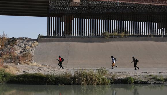 Migrantes corren después de cruzar el Río Bravo para buscar asilo político en Estados Unidos, visto desde Ciudad Juárez, estado de Chihuahua, México, el 6 de diciembre de 2021. (Foto: HERIKA MARTINEZ / AFP)