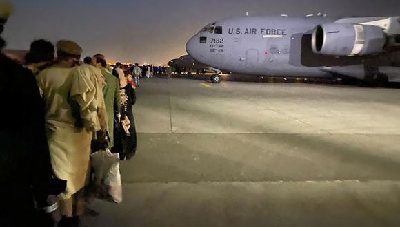 Los afganos hacen cola y abordan un avión militar estadounidense para salir de Afganistán, en el aeropuerto militar de Kabul el 19 de agosto de 2021. (Foto de Shakib RAHMANI / AFP).