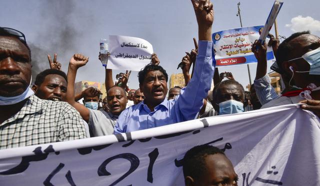 El ministro de Industria sudanés, Ibrahim al-Sheikh (C), participa en una protesta en la ciudad de Khartoum Bahri, la ciudad hermanada al norte de la capital, Jartum. (Foto de AFP)