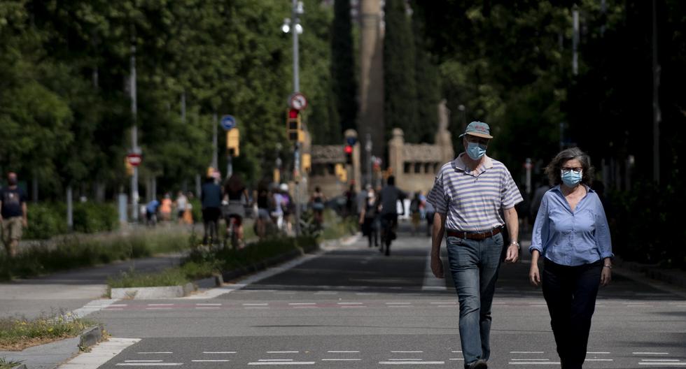 Imagen referencial. Una pareja camina en medio de la pandemia del coronavirus en una calle de España. (Josep LAGO / AFP).