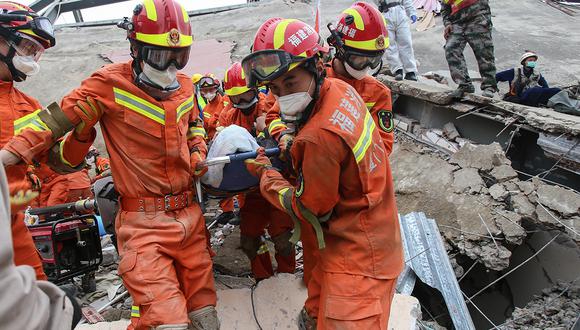 Un hombre es rescatado de los escombros de un hotel derrumbado en Quanzhou, donde habían personas en cuarentena por coronavirus. (Foto: AFP)