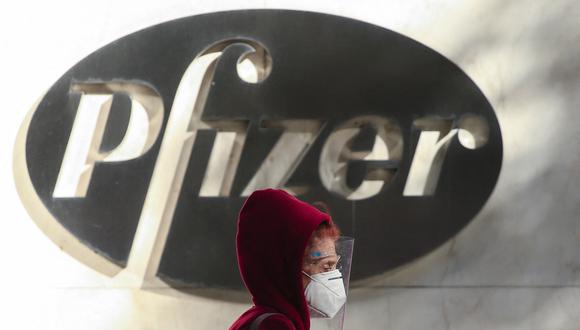 Una mujer usa una mascarilla mientras camina por la sede mundial de Pfizer en Nueva York el 9 de noviembre de 2020. (Foto: Kena Betancur / AFP)