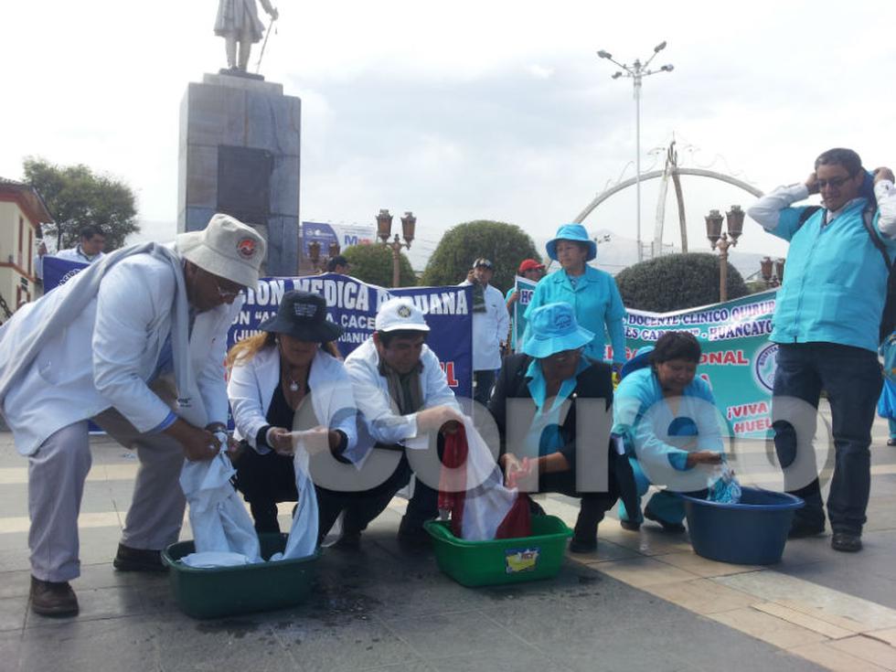 Médicos y enfermeras lavan mandiles y bandera 