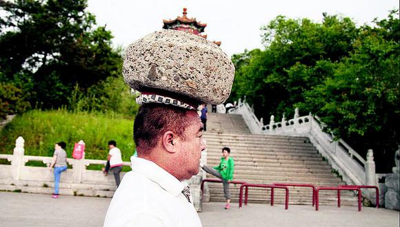 China: Hombre ​camina con una roca en la cabeza para bajar de peso (FOTOS)