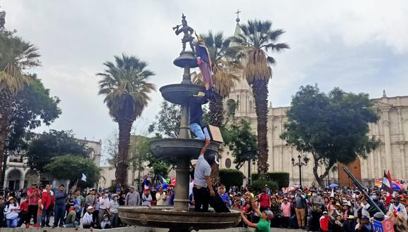 Manifestantes suben al Tuturutu de la Plaza de Armas de Arequipa para colocar el muñeco de Dina Boluarte| Foto: Omar Cruz