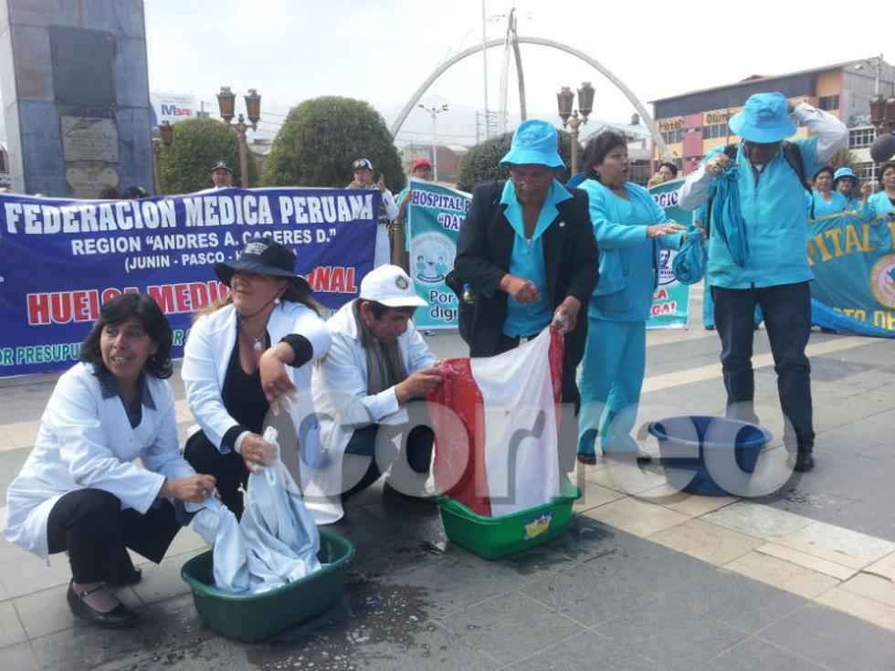 Médicos y enfermeras lavan mandiles y bandera 
