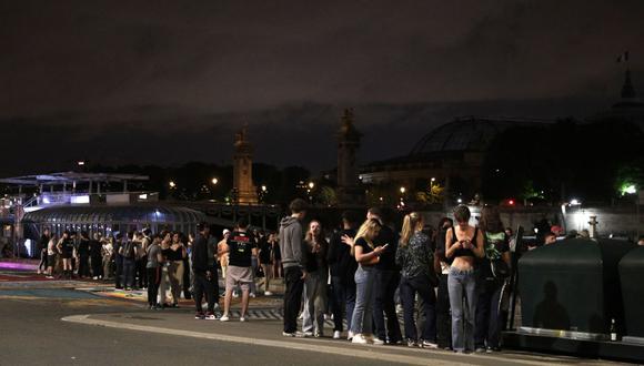 La gente se para en una calle cerca de Les Invalides en París después del toque de queda por el coronavirus. (GEOFFROY VAN DER HASSELT / AFP).