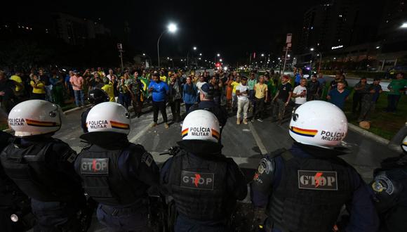 Los partidarios del presidente Jair Bolsonaro se enfrentan a la policía militar mientras protestan contra el arresto de un líder indígena en Brasilia el 12 de diciembre de 2022. (Foto de EVARISTO SA / AFP)