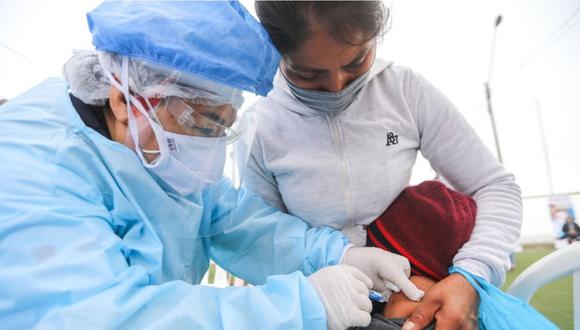 Una especialista de salud vacunando a un menor de edad. | Foto: EsSalud.