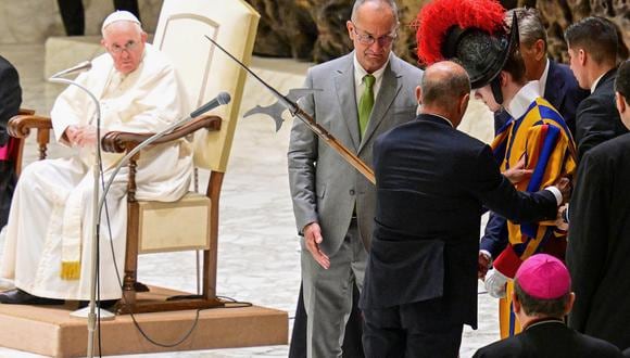La gente ayuda a un guardia suizo a levantarse después de que se desmayó durante la audiencia general semanal del Papa Francisco el 17 de agosto de 2022 en la sala Paul-VI en el Vaticano. (Foto de Vincenzo PINTO / AFP)