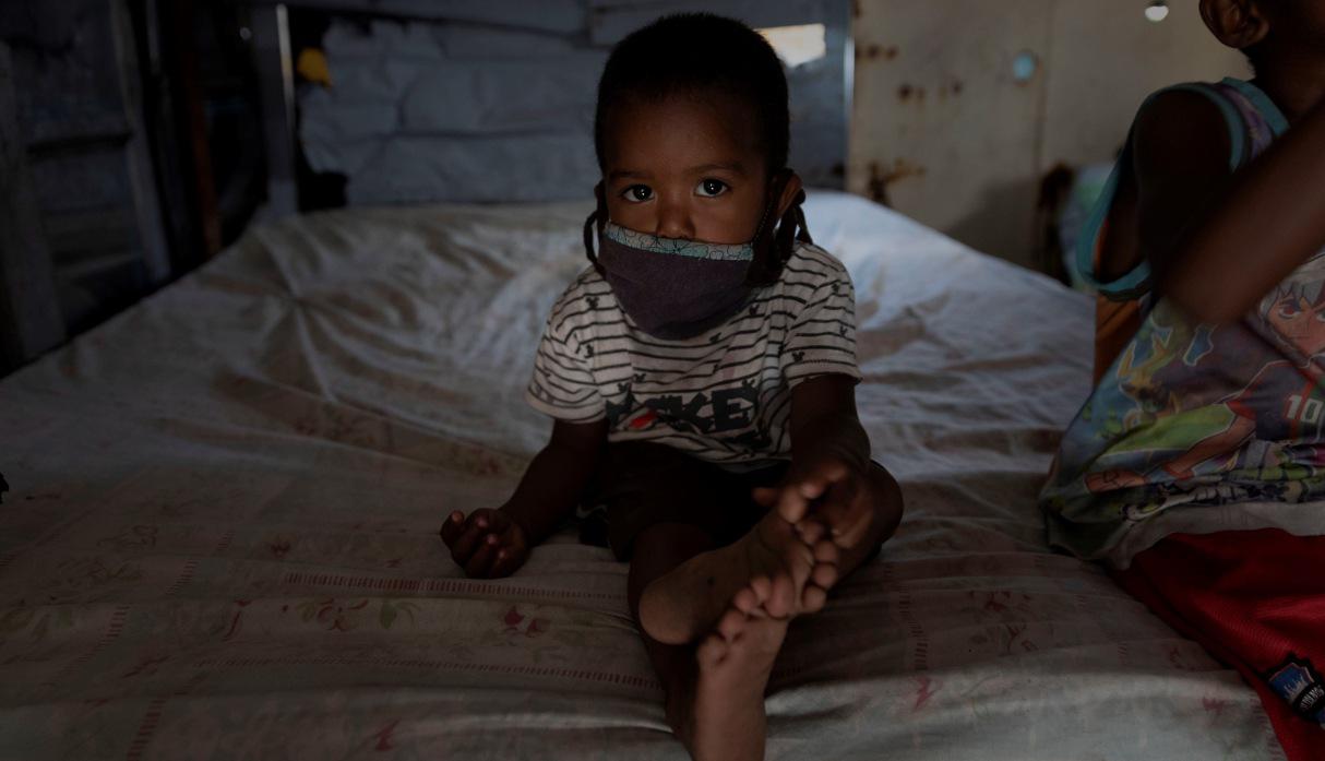 Un niño posa para un fotógrafo de EFE en su vivienda en un terreno ocupado en Caracas (Venezuela).  (EFE/ Rayner Peña R.).