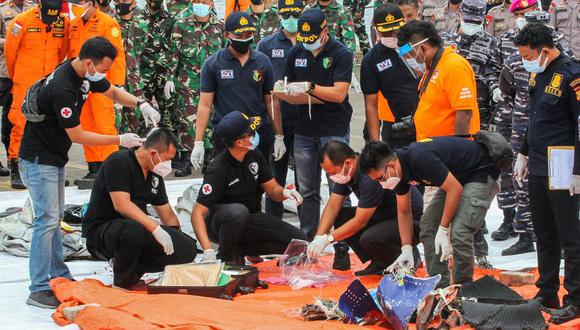 Los equipos de rescate inspeccionan los artículos recuperados y escombros del avión siniestrado del vuelo SJY182 de Sriwijaya Air, que se estrelló después de despegar de Yakarta. (Dany Krisnadhi / AFP).