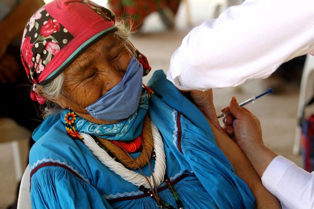 Una mujer indígena wixárika es inoculada con la vacuna CanSino Biologics contra el COVID-19 en el centro de vacunación instalado en la localidad de Nuevo Colonia, en Mezquitic, estado de Jalisco, México, el 16 de abril de 2021. (Ulises Ruiz / AFP).