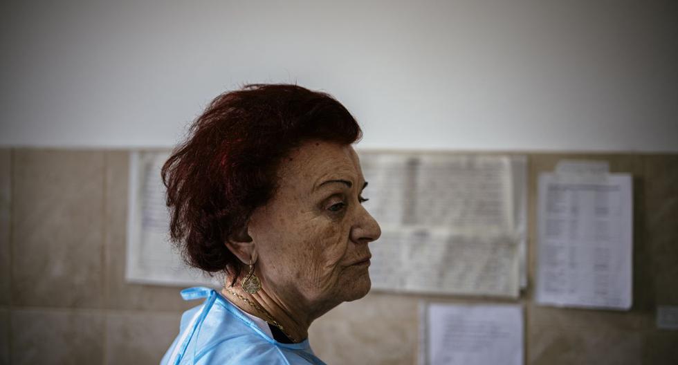 Esta fotografía tomada el 20 de enero de 2021 muestra a la doctora Maria Bogoeva, de 82 años, especialista búlgara en enfermedades infecciosas, observando durante su turno en una unidad COVID-19 en el hospital de Doupnitsa. (Dimitar DILKOFF / AFP).