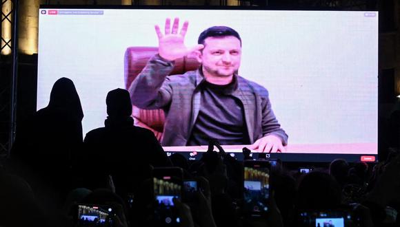 Los manifestantes ven un discurso del presidente ucraniano Volodymyr Zelensky en la pantalla grande durante una manifestación en apoyo de Ucrania en Tbilisi el 4 de marzo de 2022. (Foto de Vano SHLAMOV / AFP)