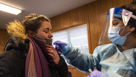 Un trabajador médico realiza una prueba de PCR a una mujer que quería hacerse la prueba de covid-19 en el Centro de Salud Comunitario de East Boston en Boston, Massachusetts. (Foto: Joseph Prezioso / AFP)