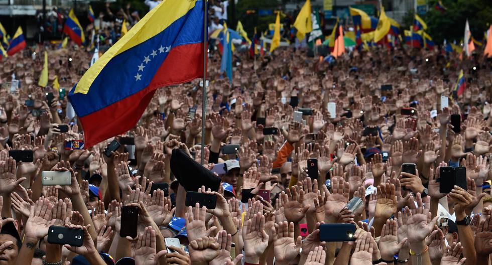 Imagen referencial. La gente levanta la mano durante una manifestación masiva de oposición contra el presidente Nicolás Maduro en Caracas. el 23 de enero de 2019. (Federico PARRA / AFP).