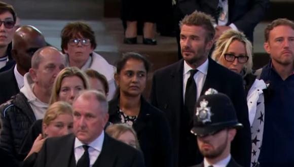 David Beckham, de 47 años, fue descubierto por la prensa mientras esperaba en la fila, vestido con traje, corbata y abrigo negros.  (Foto: captura YouTube)