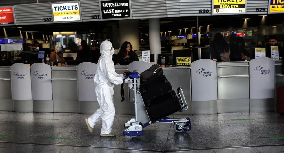 Un pasajero con traje protector espera el check-in en el Aeropuerto Internacional de Frankfurt en Frankfurt am Main, en el oeste de Alemania, el 19 de diciembre de 2020. (Armando BABANI / AFP).