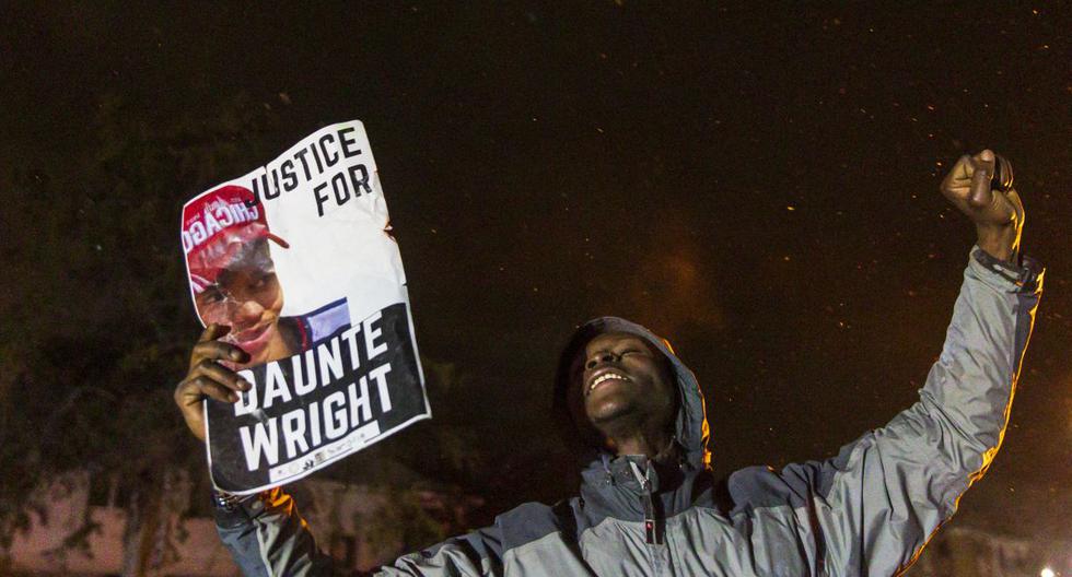 Un manifestante sostiene una foto de Daunte Wright y grita "No disparen" a la policía después del toque de queda mientras protestaban por la muerte de Daunte Wright, en Brooklyn Center, Minnesota, el 13 de abril de 2021. (Kerem YUCEL / AFP).