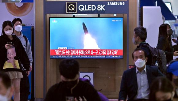 La gente mira una pantalla de televisión que muestra una transmisión de noticias con imágenes de archivo de una prueba de misiles de Corea del Norte, en una estación de tren en Seúl el 29 de septiembre de 2022. (Foto de Jung Yeon-je / AFP)