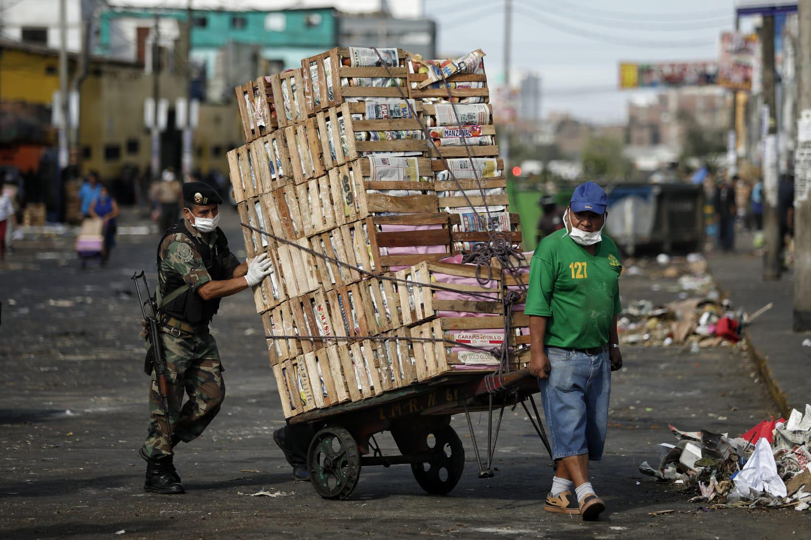Policía es captado ayudando a estibador en Mercado de Frutas. Fotos: Miguel Yovera/GEC