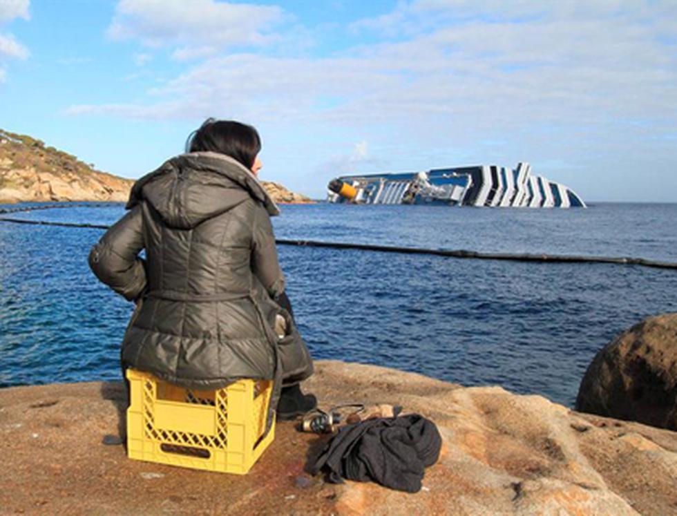 Turistas de desastre posan ante el crucero "Costa Concordia"