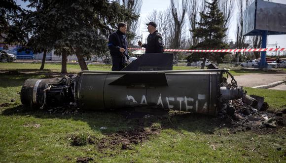 La policía ucraniana inspecciona los restos de un gran cohete con las palabras "para nuestros hijos" en ruso junto al edificio principal de una estación de tren en Kramatorsk, al este de Ucrania, que estaba siendo utilizada para evacuaciones civiles, que fue alcanzada por un ataque con cohetes que mató al menos 35 personas, el 8 de abril de 2022. (Foto de FADEL SENNA / AFP)