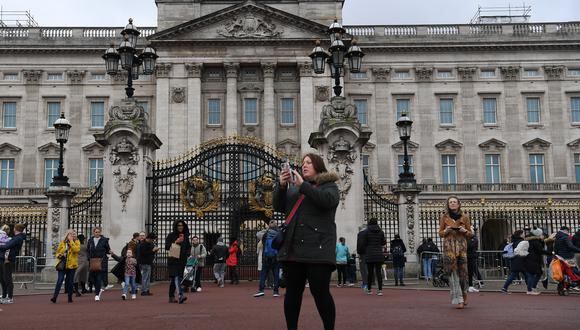 La gente se reúne frente a las puertas del Palacio de Buckingham en Londres el 20 de febrero de 2022. (Foto: Daniel LEAL / AFP)