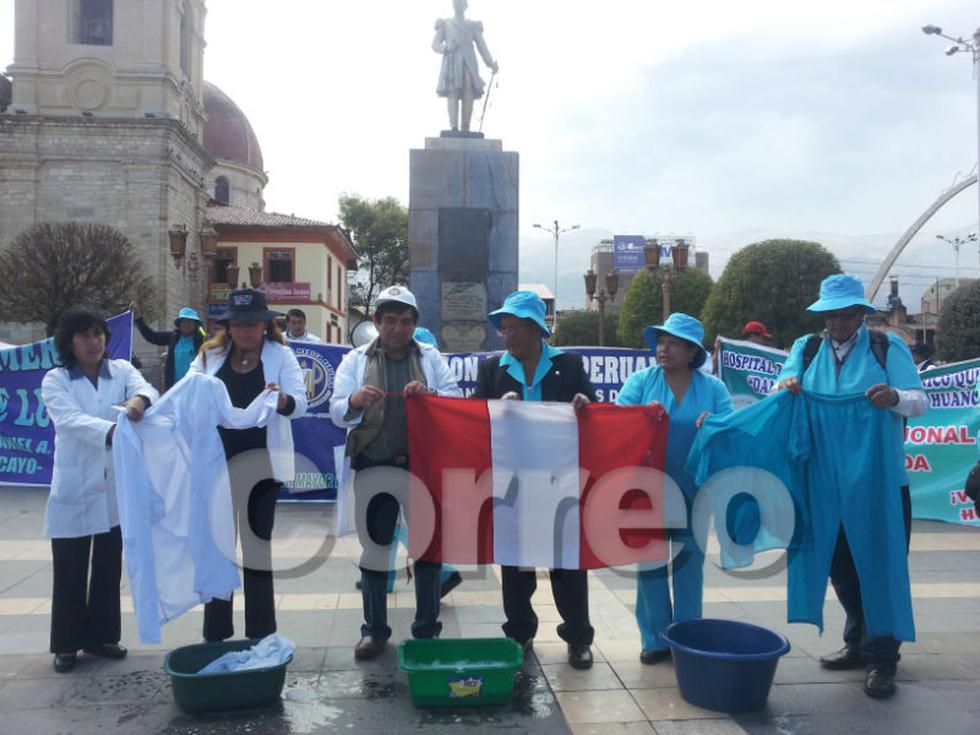 Médicos y enfermeras lavan mandiles y bandera 