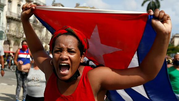 Una mujer manifiesta su apoyo al gobierno de Cuba en una calle en La Habana mientras cientos de cubanos protestan contra el régimen también en la capital. (EFE/Ernesto Mastrascusa).