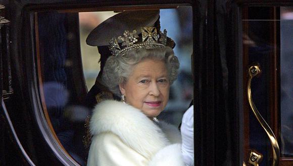 La reina Isabel II saluda a la multitud desde su carruaje tirado por caballos cuando sale del palacio de Buckingham para la apertura del parlamento en Londres, el 6 de diciembre de 2000. (Foto de Odd ANDERSEN / AFP)