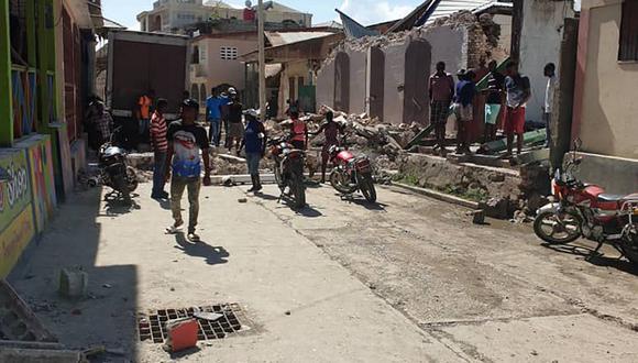 La gente observa las casas destruidas después de un terremoto el 14 de agosto de 2021 en Jeremie, suroeste de Haití. (Tamas JEAN PIERRE / AFP)