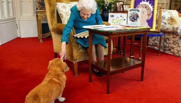 En esta imagen de archivo publicada en Londres el 4 de febrero de 2022, se muestra a la reina Isabel II de Gran Bretaña acariciando a Candy, su perro corgi. (Foto:  Steve Parsons / POOL / AFP)