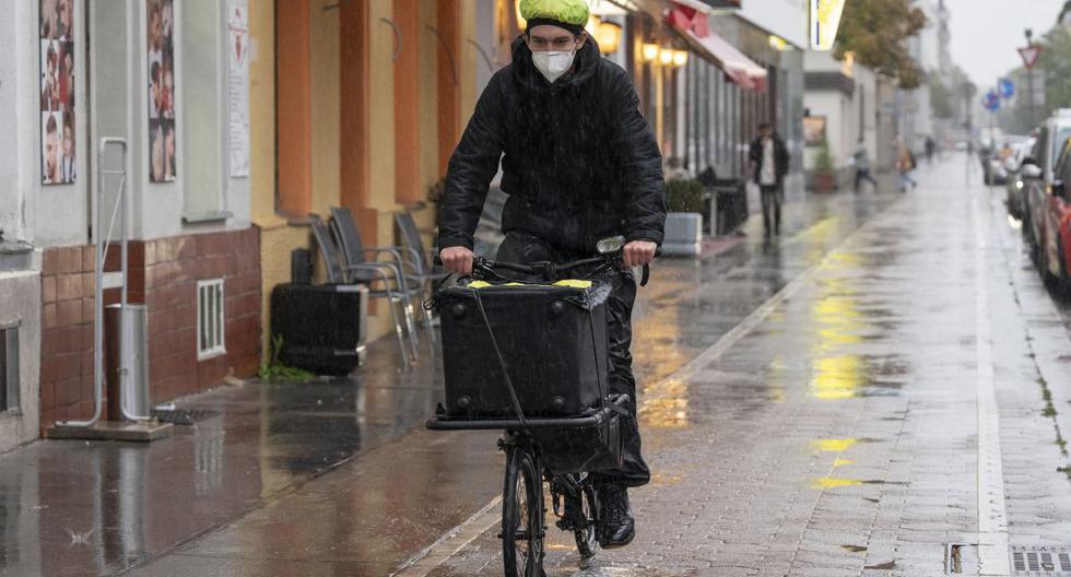 Un hombre conduce su bicicleta a un edificio residencial para realizar pruebas de coronavirus en Viena, Austria, el 13 de octubre de 2020. (JOE KLAMAR / AFP).