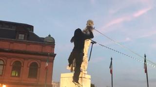 Estados Unidos: Derriban estatua de Colón y queman baderas en noche de protestas  (VIDEO)