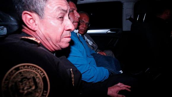 El expresidente del Perú Pedro Castillo (centro) dentro de un carro de la policía cuando sale de la prefectura de Lima, donde estaba detenido, el 7 de diciembre de 2022. (RENATO PAJUELO / AFP).