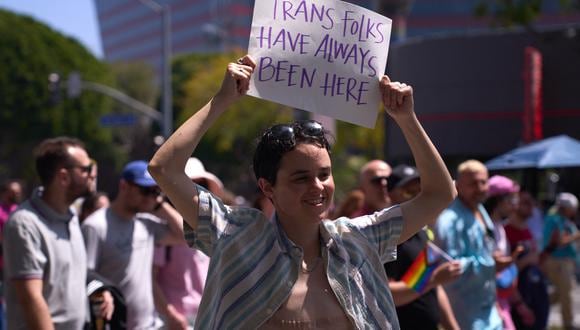Una persona transgénero sostiene un cartel que dice "Las personas trans siempre han estado aquí" mientras los activistas LGBTQ+ marchan durante la "Marcha Drag LA: La marcha en el bulevar Santa Mónica" del Centro LGBT de Los Ángeles, en West Hollywood, California, el domingo de Pascua el 9 de abril. 2023. (Foto de ALLISON DINNER / AFP)