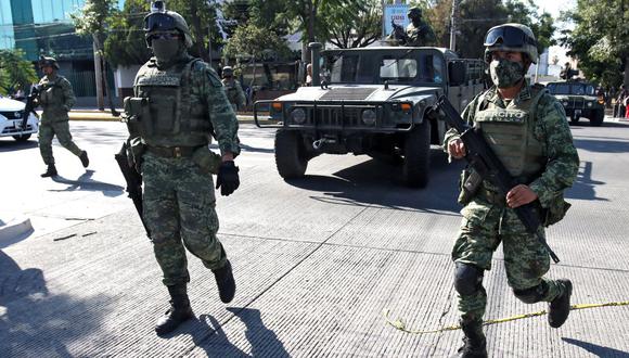 Elementos del Ejército vigilan la calle mientras participan en un operativo de las Fuerzas Armadas en el barrio Jardines de Alcalde en Guadalajara, México, en el que se detuvo y trasladó a personas, el 2 de diciembre de 2021. (Foto de Ulises RUIZ / AFP)