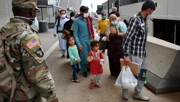 Los refugiados afganos abordan un autobús después de llegar al Aeropuerto Internacional de Dulles el 27 de agosto de 2021 en Dulles, Virginia, luego de ser evacuados de Kabul luego de la toma de Afganistán por los talibanes. (Olivier DOULIERY / AFP).